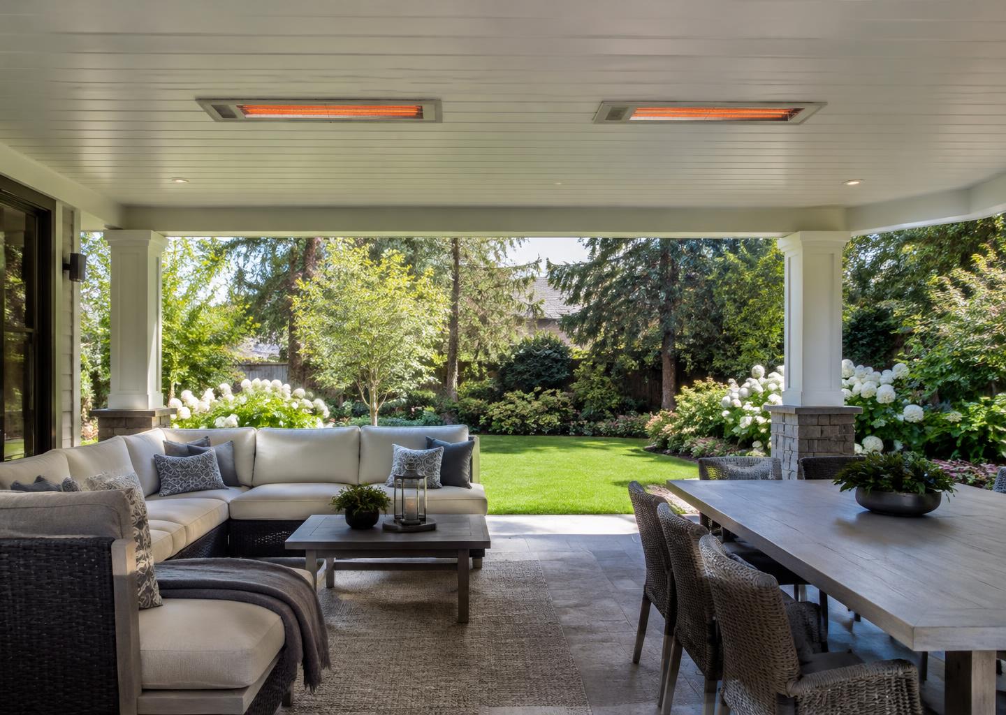 Two flush-mounted infrared heaters above a covered garden lounge and dining area